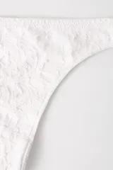 Conjunto de lencería color piel con pequeños lunares en relieve. Incluye un corpiño triangular con breteles finos y una bombacha colaless.