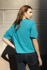 Remera negra de algodón con corte cuadrado, cuello redondo y logo bordado en color naranja.