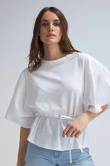 Camiseta blanca de algodón con mangas abullonadas y lazo ajustable en la cintura.
