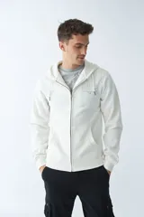 Campera de felpa color beige con cierre frontal, capucha con cordón ajustable, bolsillos laterales y logo estampado en el pecho.