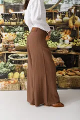 Pantalón de lino color crudo con finas rayas verticales negras, corte wide leg y tiro alto.