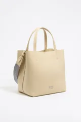 Bolso tote negro de cuero vacuno con doble asa corta y correa de tela extraíble. Interior con tres compartimentos y bolsillo con cremallera. Logo metálico de la marca en el frente.