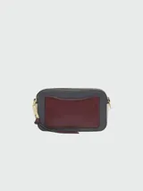 Bandolera Marc Jacobs modelo The Snapshot, de cuero color gris con detalles en beige y herrajes dorados. Presenta correa de tela con el logo de la marca y doble compartimento con cierre.