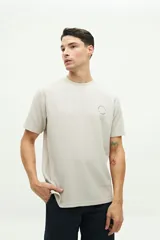 Remera color beige con textura, de manga corta, corte regular y logo estampado en el pecho.