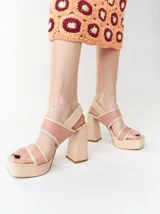 Sandalias de plataforma color naranja con detalles en marrón. Tienen tiras anchas sobre el empeine y el tobillo, y un tacón cuadrado alto.