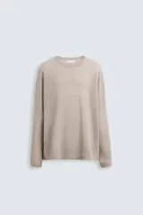 Jersey color beige de punto tejido en hilatura ligera de lino, con cuello redondo, manga larga y acabados en rib.