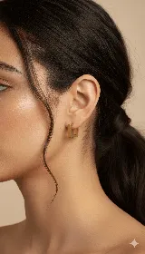 Par de aros tipo argolla cuadrados, de acero dorado.