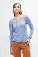 Remera gris de corte ajustado, con cuello redondo y mangas largas. Presenta líneas verticales bordadas en color verde claro y blanco.