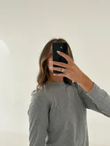 Remera manga larga color verde oliva, confeccionada en tejido morley de algodón con detalle fruncido en los hombros.