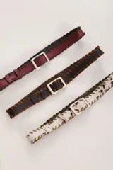 Cinto de cuero color marrón con costuras de tientos en los bordes y hebilla metálica plateada.