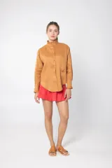 Camisa color ocre de lino con cuello alto con volados y bordado de flor en el frente.