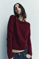 Jersey rojo de punto liso confeccionado en 100% lana. Tiene cuello redondo, manga larga y acabados en rib.