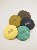 Gorro tipo bucket color mostaza con cinta decorativa a rayas horizontales en tonos bordó, amarillo y azul marino.