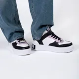 Zapatillas de media caña blancas con detalles en negro y lila. Cierre con cordones negros y tira de velcro blanca con la palabra "Friends".