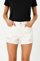 Short de jean color beige, tiro alto, con bolsillos delanteros y traseros, roturas y ruedo desflecado.