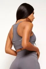 Top deportivo gris con diseño nadador, confeccionado en poliamida de alta performance. Cuenta con bolsillo trasero y bolsillo interno en el forro frontal.