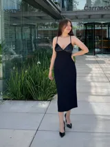 Vestido midi negro con breteles finos, escote en V y corpiño con lentejuelas.