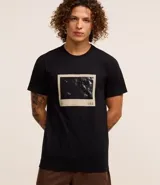 Remera negra de algodón con estampa photoprint del mar con tablas de surf.