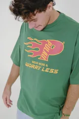 Remera verde con estampa en el frente con el logo de la marca y la frase 'Wear More & Worry Less'.