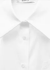 Camisa blanca de popelina de algodón y lyocell, con bordado floral en el frente, corte oversize, cuello camisero, mangas largas con puños abotonados y cierre frontal con botones.