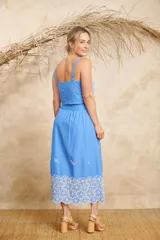 Conjunto de pollera midi y crop top celeste, con bordado de flores blancas.