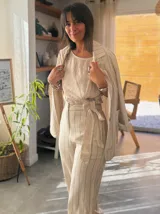 Blazer de lino color crudo con rayas verticales finas en color azul marino, con solapas clásicas, cierre con dos botones de madera y bolsillos delanteros.