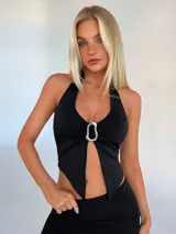 Top halter negro con escote en V y abertura en el abdomen, con detalle de aro metálico en el centro.
