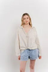 Camisa color crema de manga larga con cuello camisero y detalles de encaje en el escote. Se ata en la parte delantera.