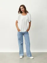Blusa blanca de mangas cortas con escote redondo y lazos.