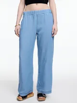 Pantalón celeste de pierna recta y calce relajado, confeccionado en denim 100% lyocell con cintura elástica, bolsillos laterales y pespuntes en color contraste.