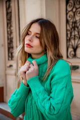 Sweater verde esmeralda de punto trenzado, con cuello alto y mangas largas.