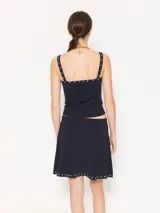 Top negro ajustado al cuerpo, con breteles finos y detalle de piedras en el escote.