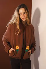 Bomber negra con rayas verticales blancas y flores rojas bordadas. Tiene cierre frontal y bolsillos.