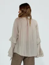 Camisa color beige de mangas largas con volados.