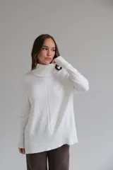 Sweater blanco de corte recto con cuello alto y aberturas laterales.
