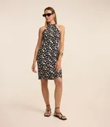 Vestido corto sin mangas confeccionado en crepé con cuello halter y estampa abstracta en blanco y negro.