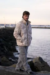 Campera puffer de corderoy con estampado paisley en tonos beige y cuello alto.