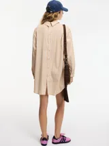 Camisa larga tipo vestido a rayas verticales color beige y blanco, con botones en la parte delantera y trasera.