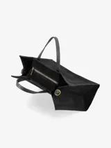 Cartera estructurada de gamuza color negro, con doble asa de mano y correa regulable y desmontable.