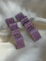 Par de aros colgantes con forma rectangular y diseño ondulado, cubiertos de strass color lila.