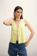 Chaleco amarillo pálido con escote en V y cierre frontal con lazos.