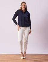 Camisa blanca de gasa, marca Sioni, con cuello con solapa, abertura central con botones y mangas largas con puño y botón.
