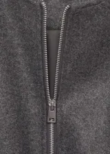 Chaqueta bomber verde oliva de lana con cierre frontal con cremallera, cuello redondo, puños y bajo elásticos.
