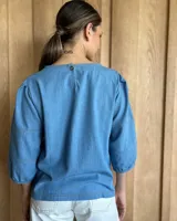 Blusa color rosa con mangas 3/4 y cuello redondo.