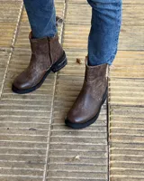 Botín marrón de cuero vacuno, con caña media, cierre lateral y suela de goma.