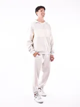 Buzo negro con cuello polo y cierre de cremallera parcial. Presenta una franja horizontal blanca en el pecho y mangas largas.