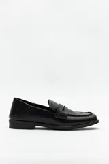 Mocasines negros de símil cuero, con punta cuadrada y detalle de bordado a tono en la capellada. Taco de 2,5cm.