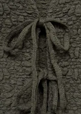 Top verde oliva de tejido texturizado, con cuello en V y cierre frontal con lazos.