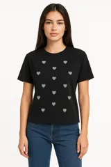 Remera negra de algodón con cuello redondo y estampado de corazones blancos.