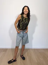 Remera corta de tafeta color verde militar con lunares de terciopelo negros, corte a la base y botón en la parte trasera.